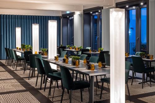 a restaurant with long tables and green chairs at The Midtown Hotel in Cologne