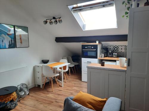una pequeña cocina con mesa y encimera en Superbe appartement pour 2, au cœur de l'Ariège! en Ussat