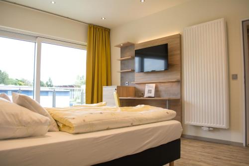 a bedroom with a bed with a flat screen tv at Motel Lohwasser in Lichtenau