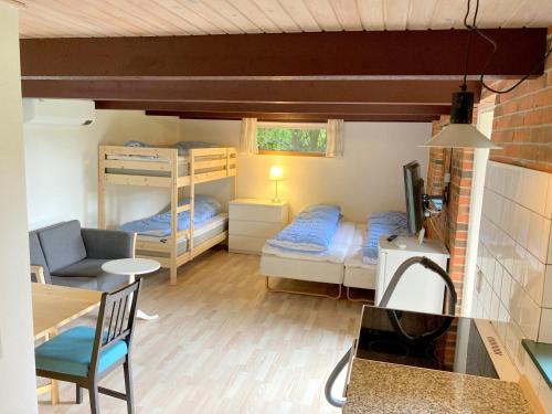 a small room with two bunk beds and a table at Skovly FerieCenter in Humble
