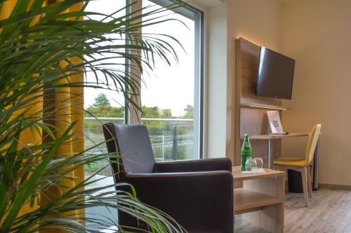 um escritório com uma cadeira, uma secretária e uma janela em Motel Lohwasser em Lichtenau