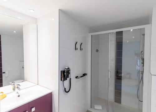 un baño con ducha y lavabo en Appart-Hôtel Mer & Golf City Bordeaux Lac, en Burdeos