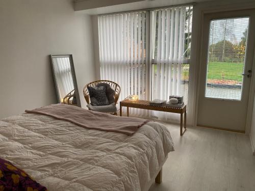 ロヴァニエミにあるScandinavian Style Villaのベッドルーム1室(ベッド1台、椅子、窓付)