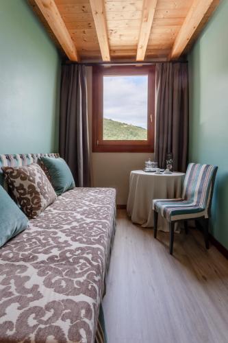 a bedroom with a bed and a table and a window at Boutique Hotel Municipio 1815 in Valdobbiadene