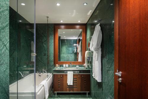 a bathroom with a tub and a sink and a mirror at Grand Hotel Sofia in Sofia