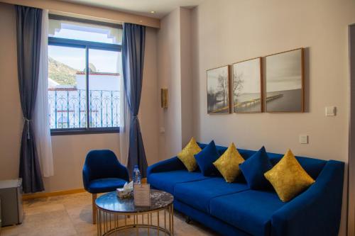 a living room with a blue couch and a table at VANCII Hotel in Chefchaouene