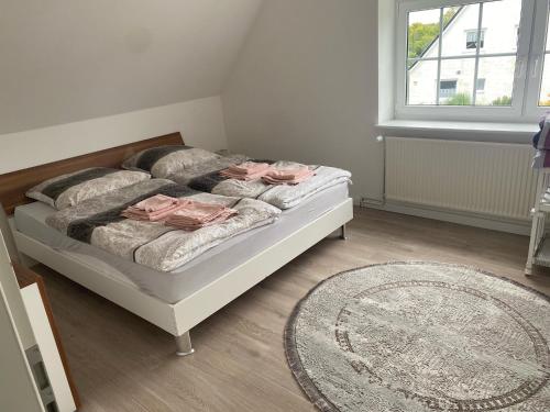 1 dormitorio con 1 cama con alfombra y ventana en Ferienwohnung Falkenfeld, en Lübeck