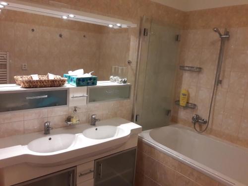 布拉格的住宿－Garden Apartment，浴室配有2个盥洗盆、淋浴和浴缸。