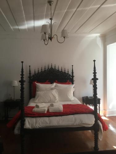 um quarto com uma cama grande e almofadas vermelhas e brancas em Palacette da Mouraria em Lisboa