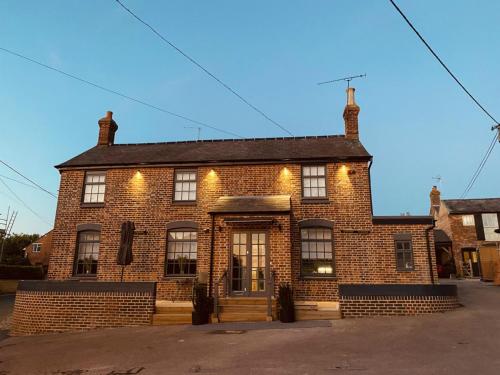 um grande edifício de tijolos com luzes em The Cherry Tree em Kingston Blount