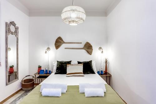 a bedroom with a bed and a chandelier at Sweet Inn - Rosemarine in Barcelona