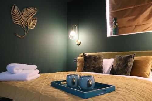 a bed with a tray with two speakers on it at The Cherry Tree Hotel in Chinnor