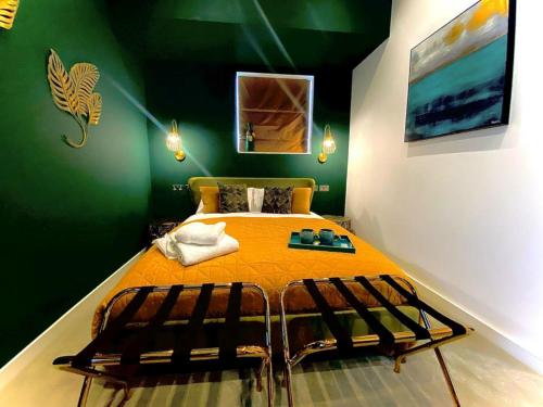 a bedroom with a bed in a green room at The Cherry Tree Hotel in Chinnor