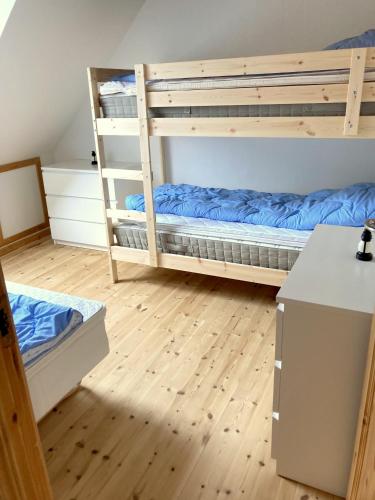a room with two bunk beds and a desk at Skovly FerieCenter in Humble