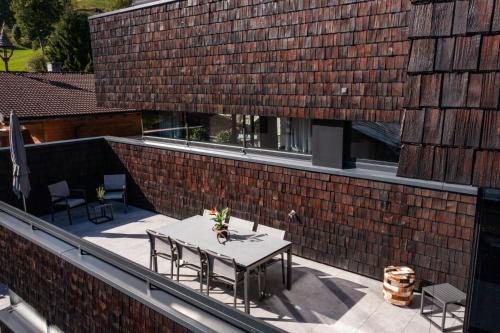 a patio with a table and chairs on a brick building at Sunny Ferienwohnungen Ski In - Ski Out - Self Check-in in Zell am See