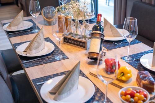 a table with a bottle of wine and plates of food at Sunny Ferienwohnungen Ski In - Ski Out - Self Check-in in Zell am See