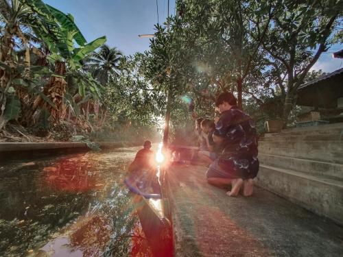 a group of children playing in a water fountain at Baan Klong Resort in Damnoen Saduak