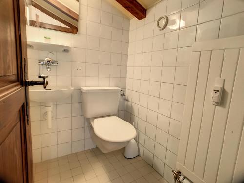 a white bathroom with a toilet and a sink at Apartment Calesberg 431 in Verbier