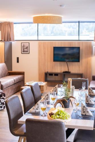 a dining room with a table and chairs and a television at Sunny Ferienwohnungen Ski In - Ski Out - Self Check-in in Zell am See