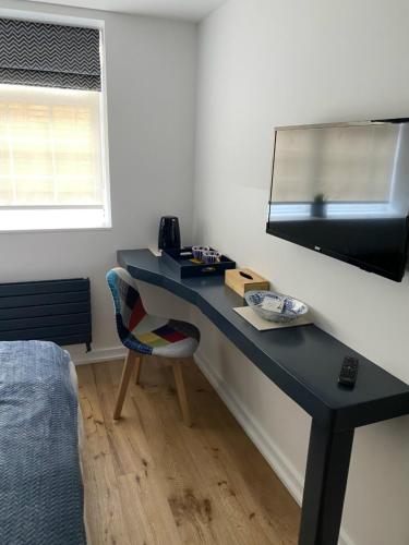 a blue desk in a room with a mirror at The Cherry Tree Hotel in Chinnor