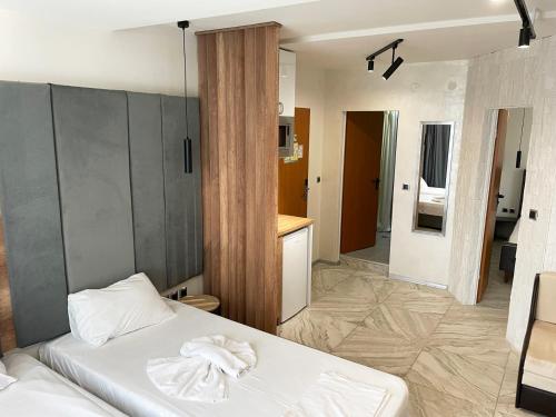 a bedroom with a white bed and a kitchen at Hotel Pacific Palma in Sunny Beach