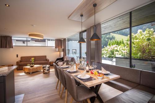 a dining room with a long table with chairs at Sunny Ferienwohnungen Ski In - Ski Out - Self Check-in in Zell am See