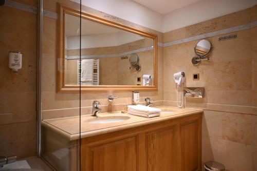 a bathroom with a sink and a shower at Hôtel Le Rempart in Tournus