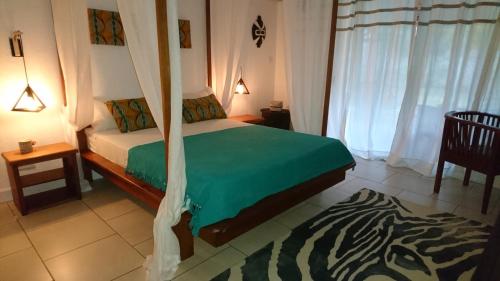 黑河區的住宿－sweet island，一间卧室配有一张带绿色棉被的床