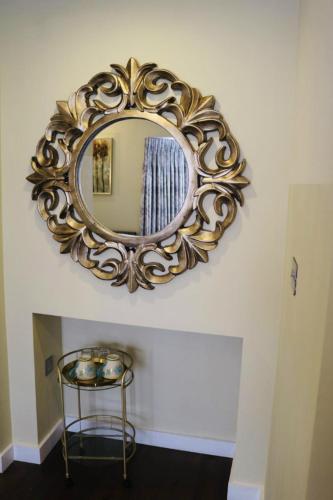 a gold mirror on a wall above a table at The Cherry Tree Hotel in Chinnor