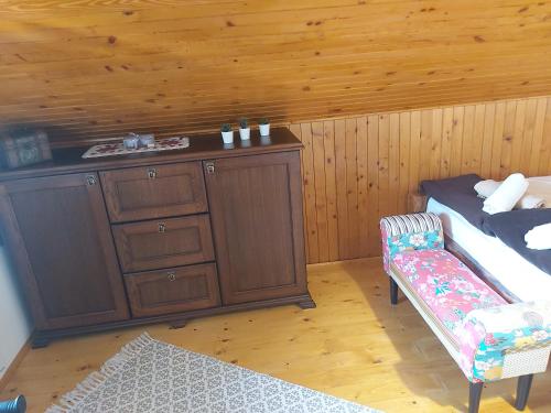 a room with a bed and a cabinet and a chair at Holiday Home Kalnik in Kalnik