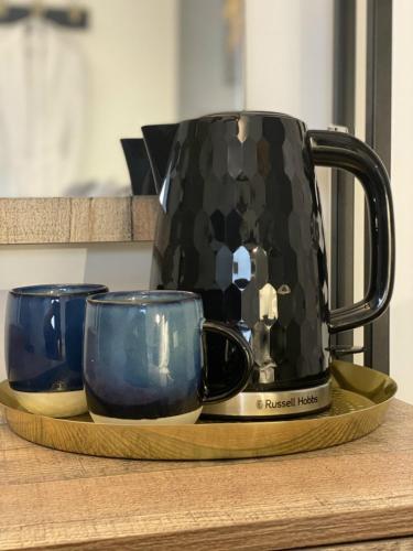 a coffee pot sitting on a tray with two mugs at The Cherry Tree Hotel in Chinnor