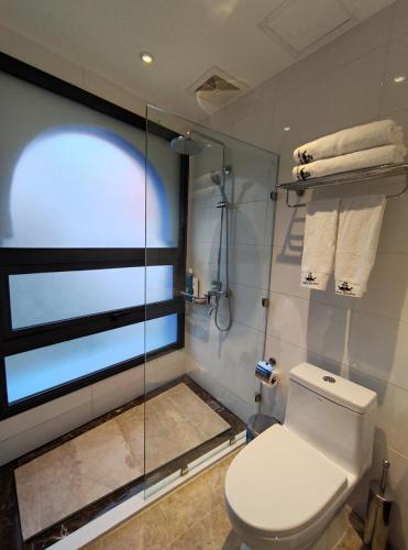 a bathroom with a toilet and a glass shower at VANCII Hotel in Chefchaouene