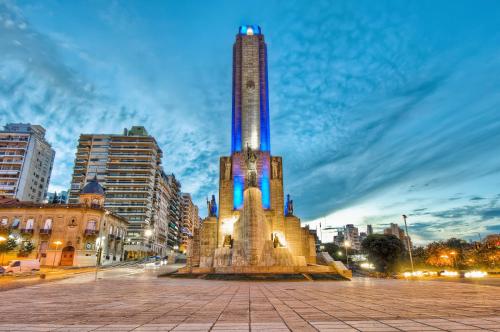a tall tower in a city at night at Luminosos y modernos departamentos en Rosario in Rosario