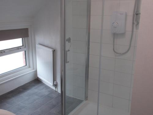 a bathroom with a shower with a glass door at Kelso House holiday flats in Blackpool