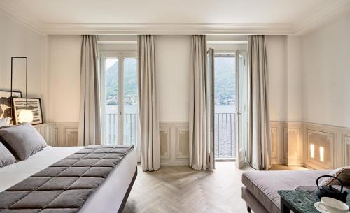 a bedroom with a bed and a large window at Villa Làrio Lake Como in Pognana Lario