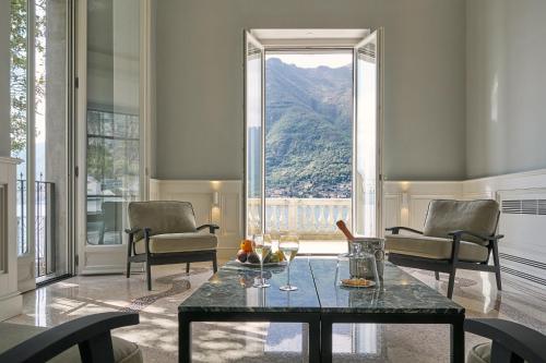 a living room with a table and chairs and a large window at Villa Làrio Lake Como in Pognana Lario