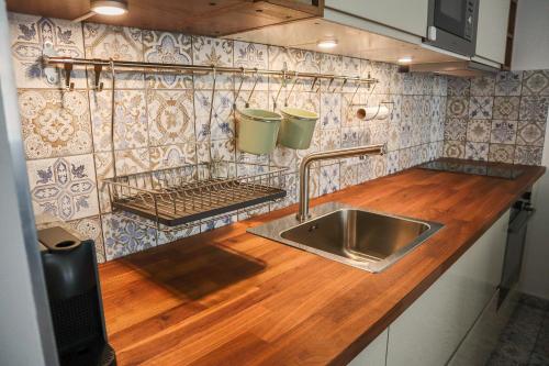 a kitchen with a sink and a wooden counter top at Baleo50 Apartment in Budapest