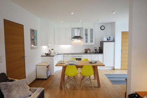 a kitchen with a table and two yellow chairs at Chalet M&M in Innsbruck