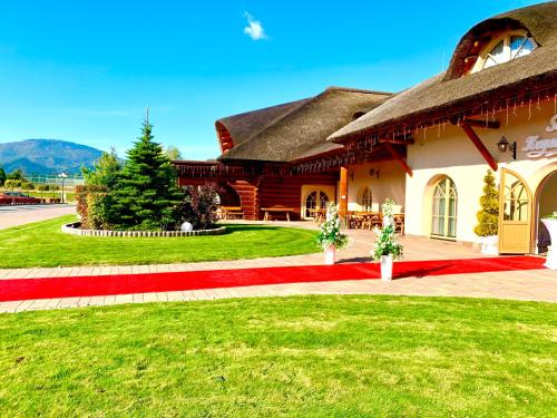 a house with a red carpet in front of it at Dworek Góralski in Łodygowice