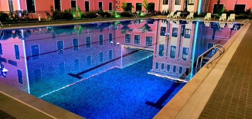 a large swimming pool in a building with a building at Golden Peacock Hotel Blantyre in Blantyre