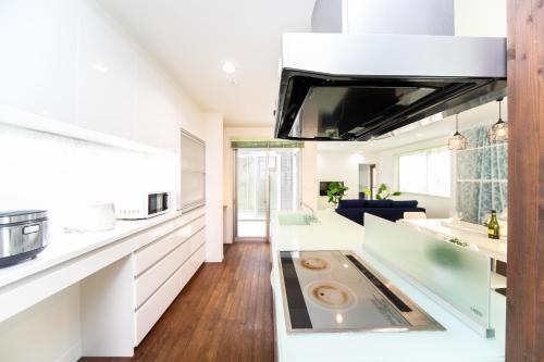 a kitchen with white cabinets and a stove top oven at Shiga Lakeside Villa in Minamishinbo in Imazu