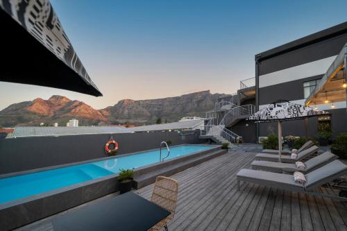 uma piscina num navio de cruzeiro com montanhas ao fundo em Kloof Street Hotel - Lion Roars Hotels & Lodges em Cidade do Cabo