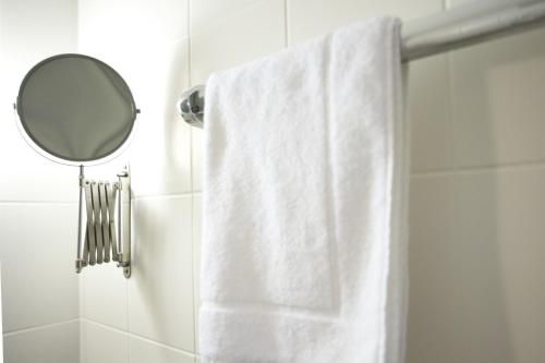 a bathroom with a white shower curtain and a mirror at Hotel Flora in Dormagen