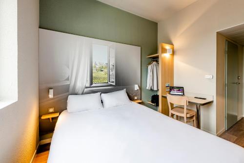 a hotel room with a bed and a television at B&B Hotel Bordeaux Est in Tresses