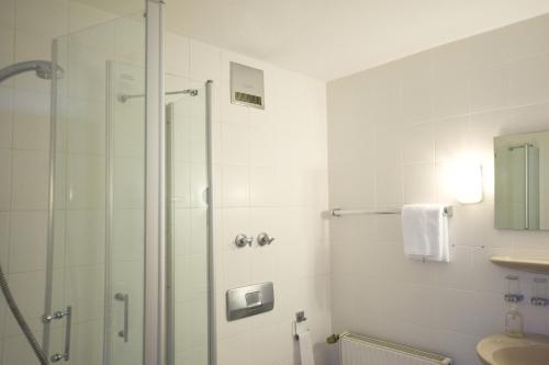 a bathroom with a shower and a sink at Hotel Flora in Dormagen