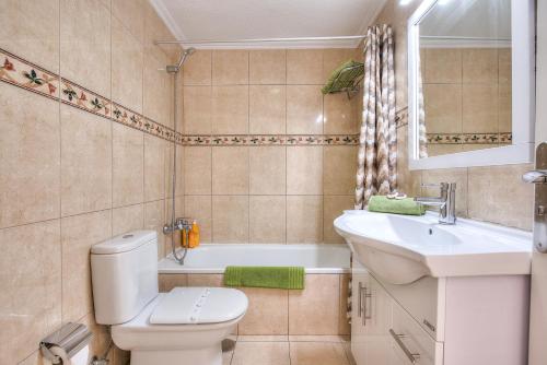 a bathroom with a toilet and a sink and a tub at Tenerife South Apartments in Playa de las Americas
