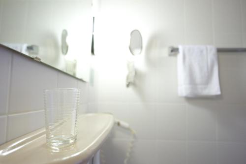 a glass vase sitting on top of a sink in a bathroom at Hotel Flora in Dormagen