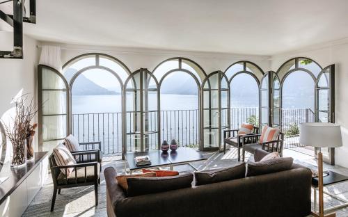 Pognana LarioにあるVilla Làrio Lake Comoのリビングルーム(アーチ型の窓、ソファ付)