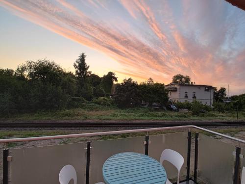 a table and chairs on a balcony with a sunset at Jolle 54 in Putbus