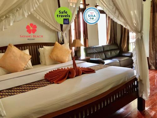 a hotel room with a bed and a canopy at Sayang Beach Resort Koh Lanta in Ko Lanta